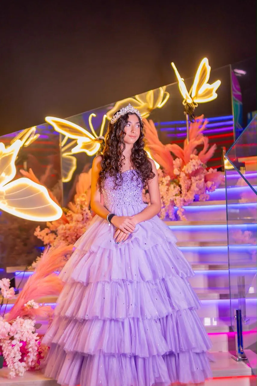 Debutante na escada iluminada com borboletas de neon do Espaço Olegário